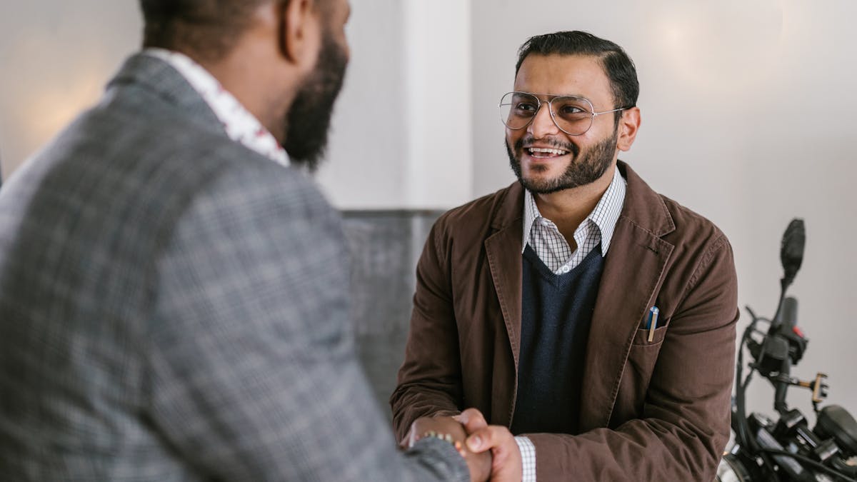 Two Indian businessmen shaking hands &mdash; partnership firm agreement